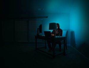 cliché hacker devant un ordi dans le noir