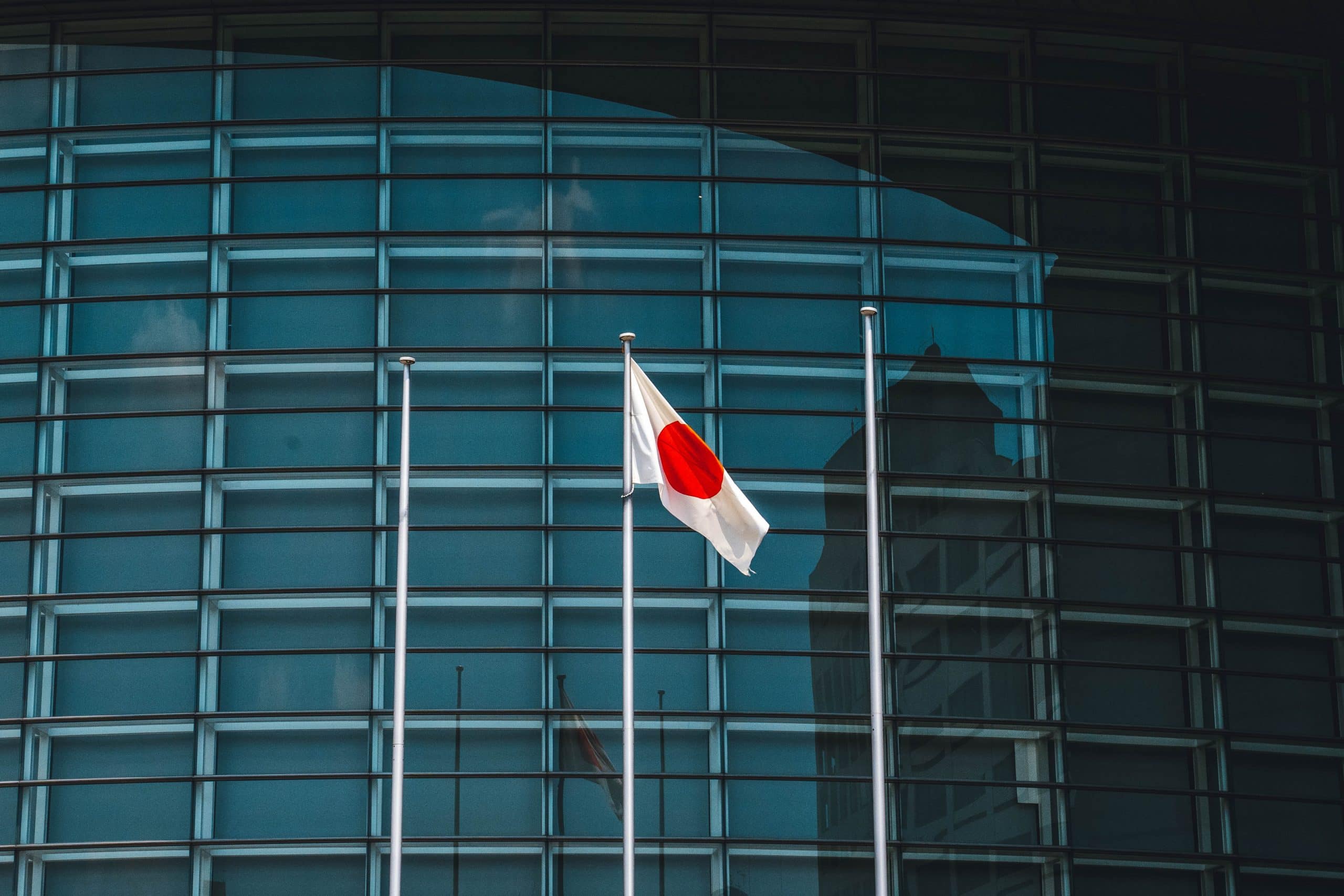 Le drapeau japonais flotte devant un bâtiment.