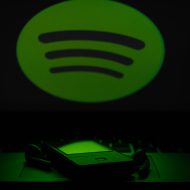 Spotify dans la pénombre éclairant un smartphone d'une lumière verte tamisée