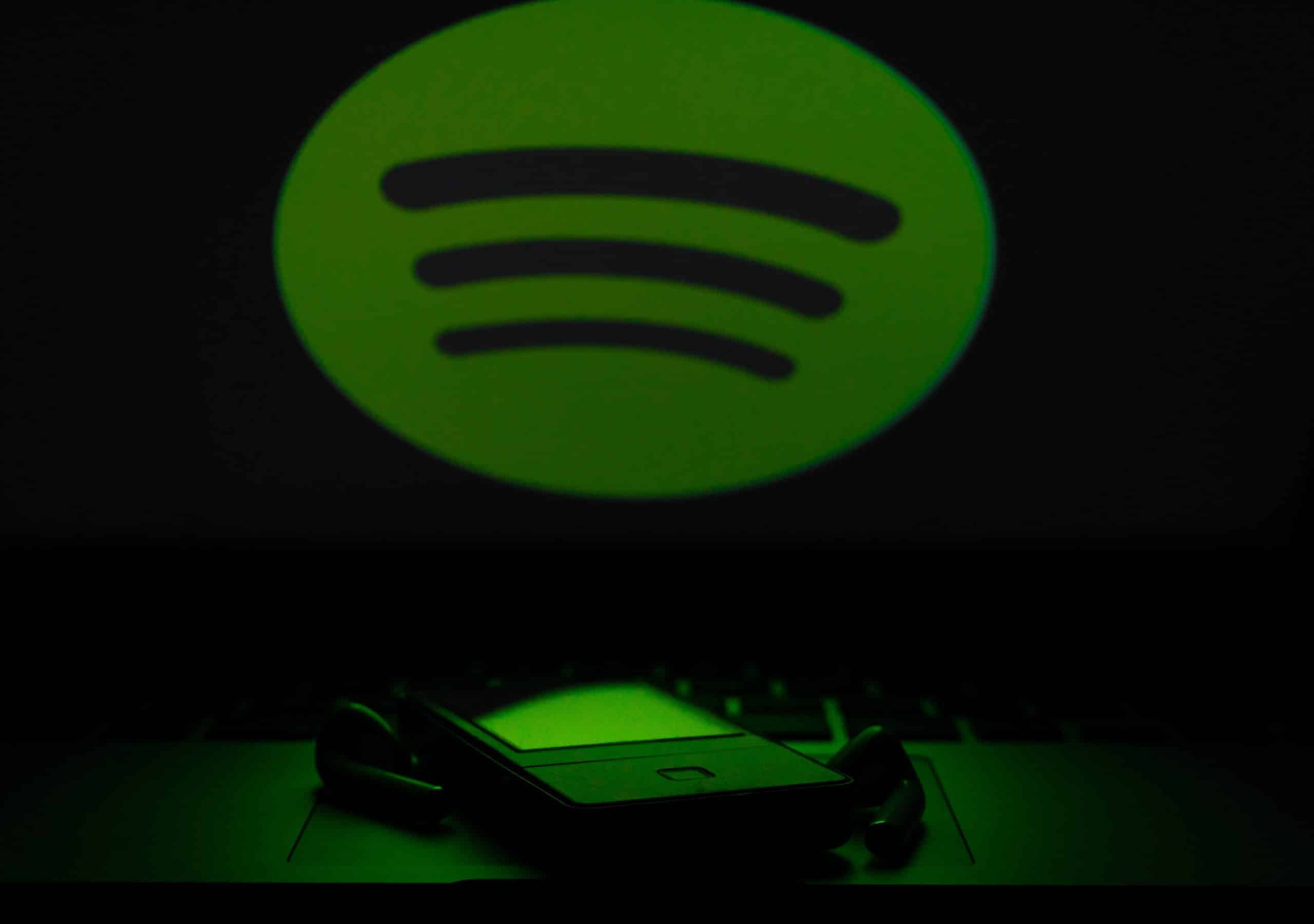 Spotify dans la pénombre éclairant un smartphone d'une lumière verte tamisée
