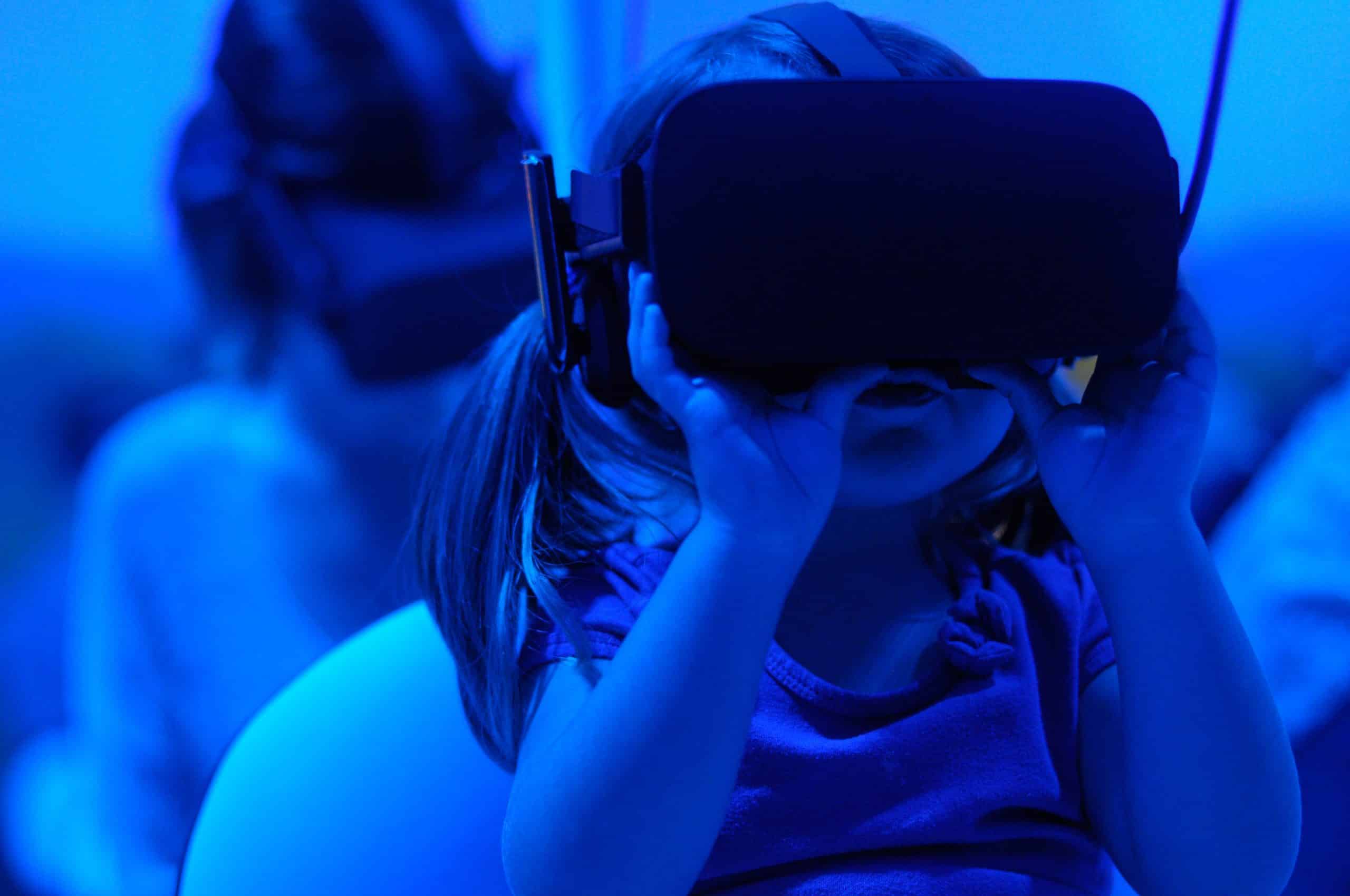 Une petite fille derrière un casque de réalité virtuelle.
