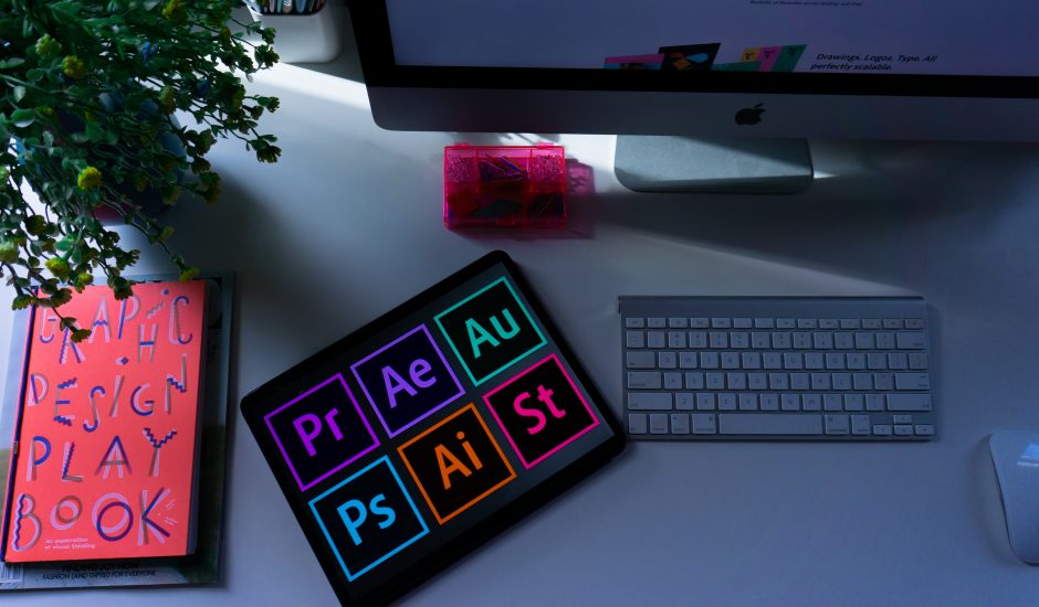 Les logos de la suite Adobe posés sur un bureau.