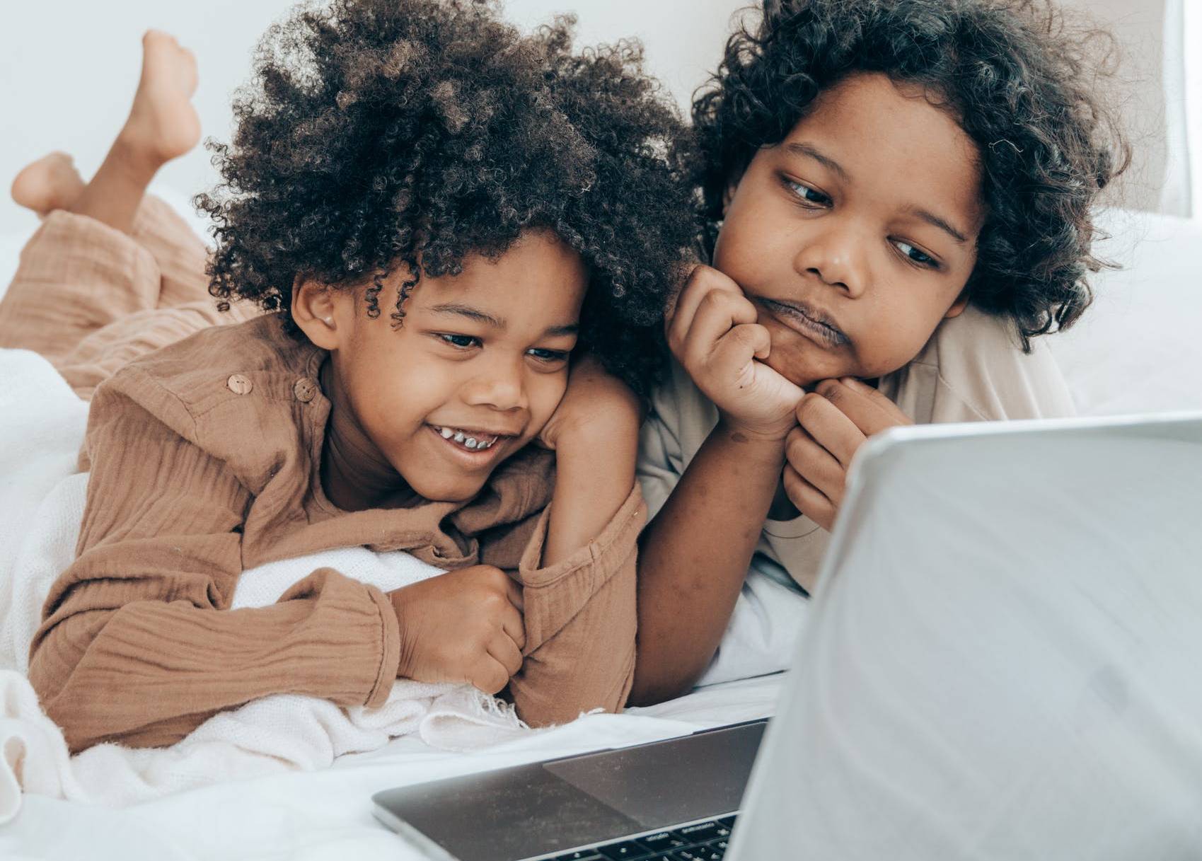 Deux enfants regardent un écran d'ordinateur portable.