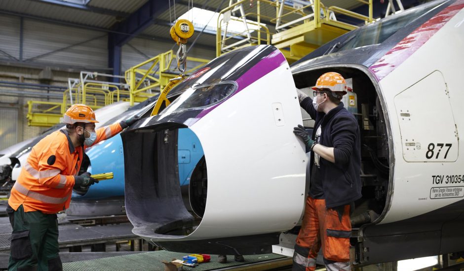 Deux techniciens SNCF assemblent un train.