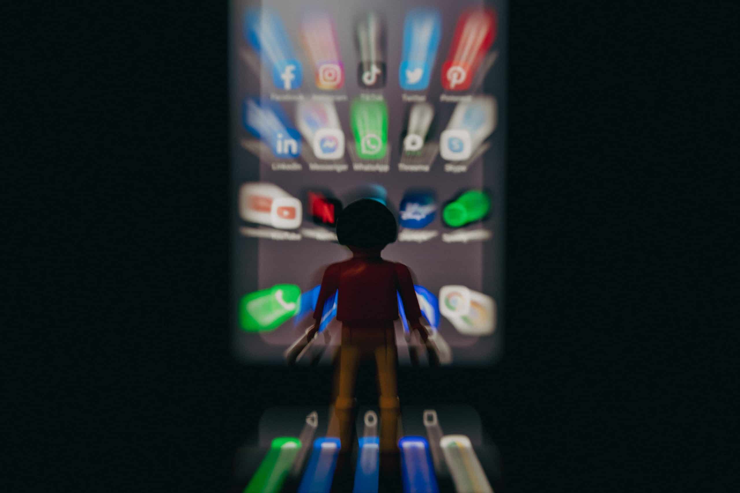 Un playmobil devant l'écran d'un téléphone.