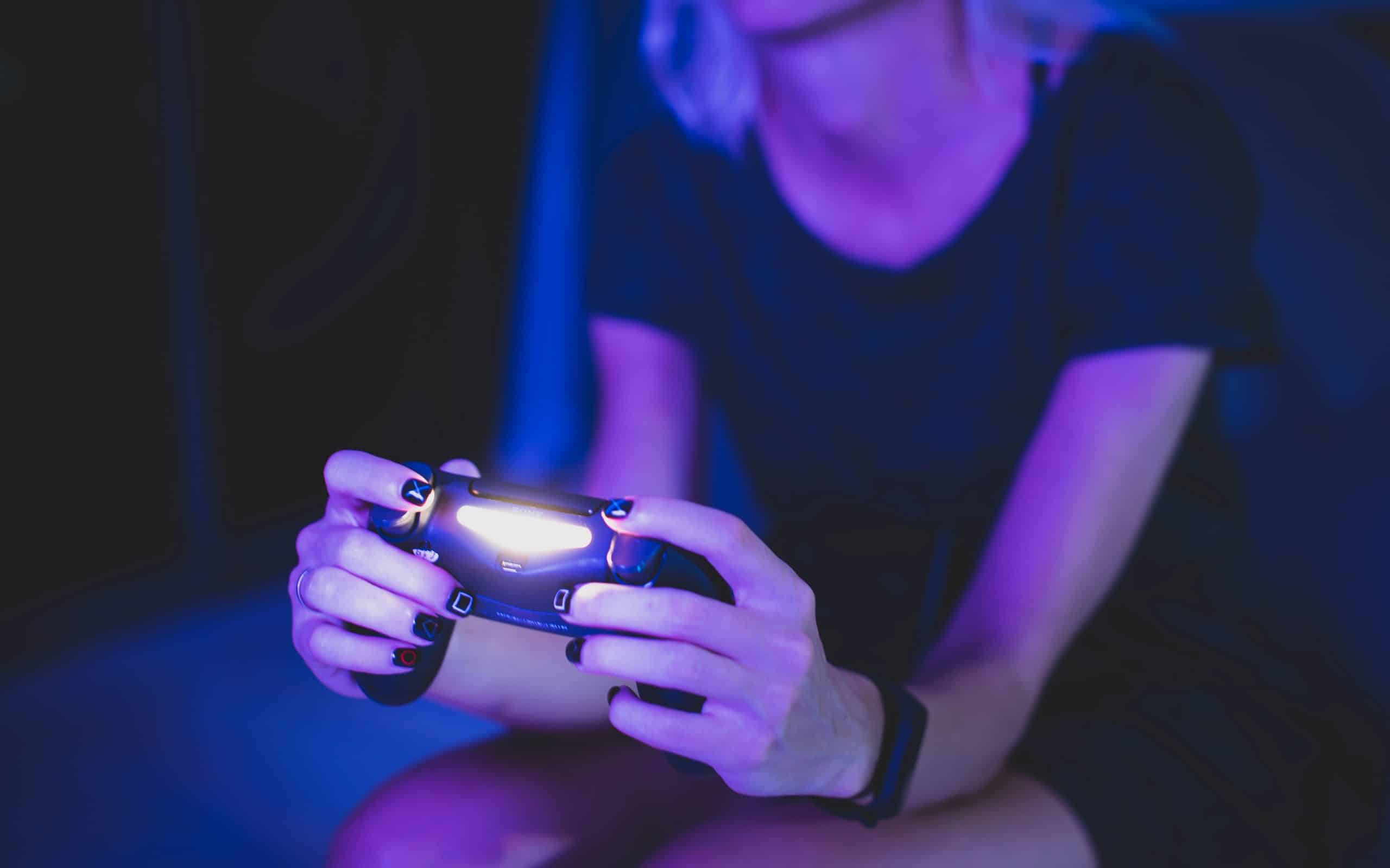 Une femme joue à la PlayStation.