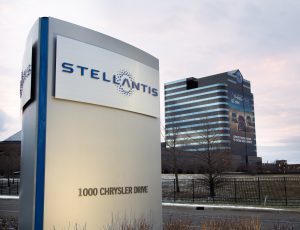 Un totem Stellantis devant un bâtiment Chrysler
