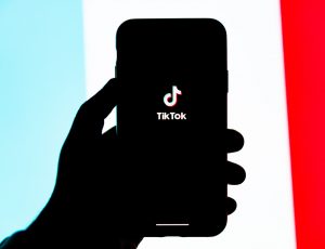 une personne tenant un téléphone avec le logo tiktok
