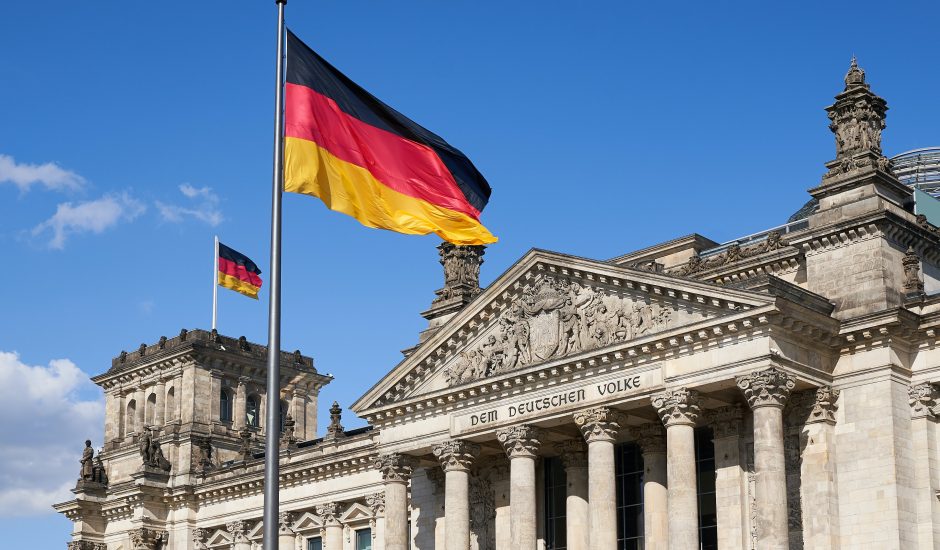 Le drapeau de l'Allemagne flotte devant un monument officiel.