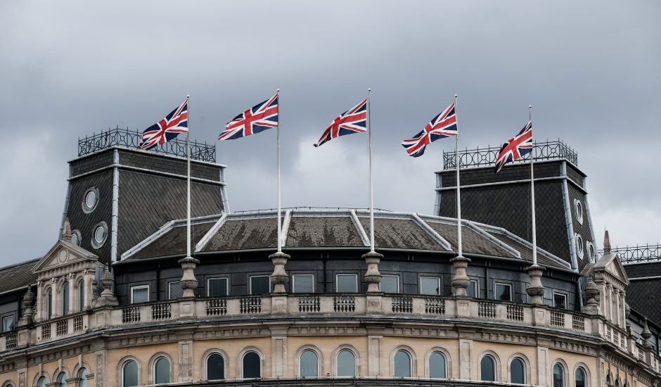 Des drapeaux britanniques flottent devant un bâtiment.