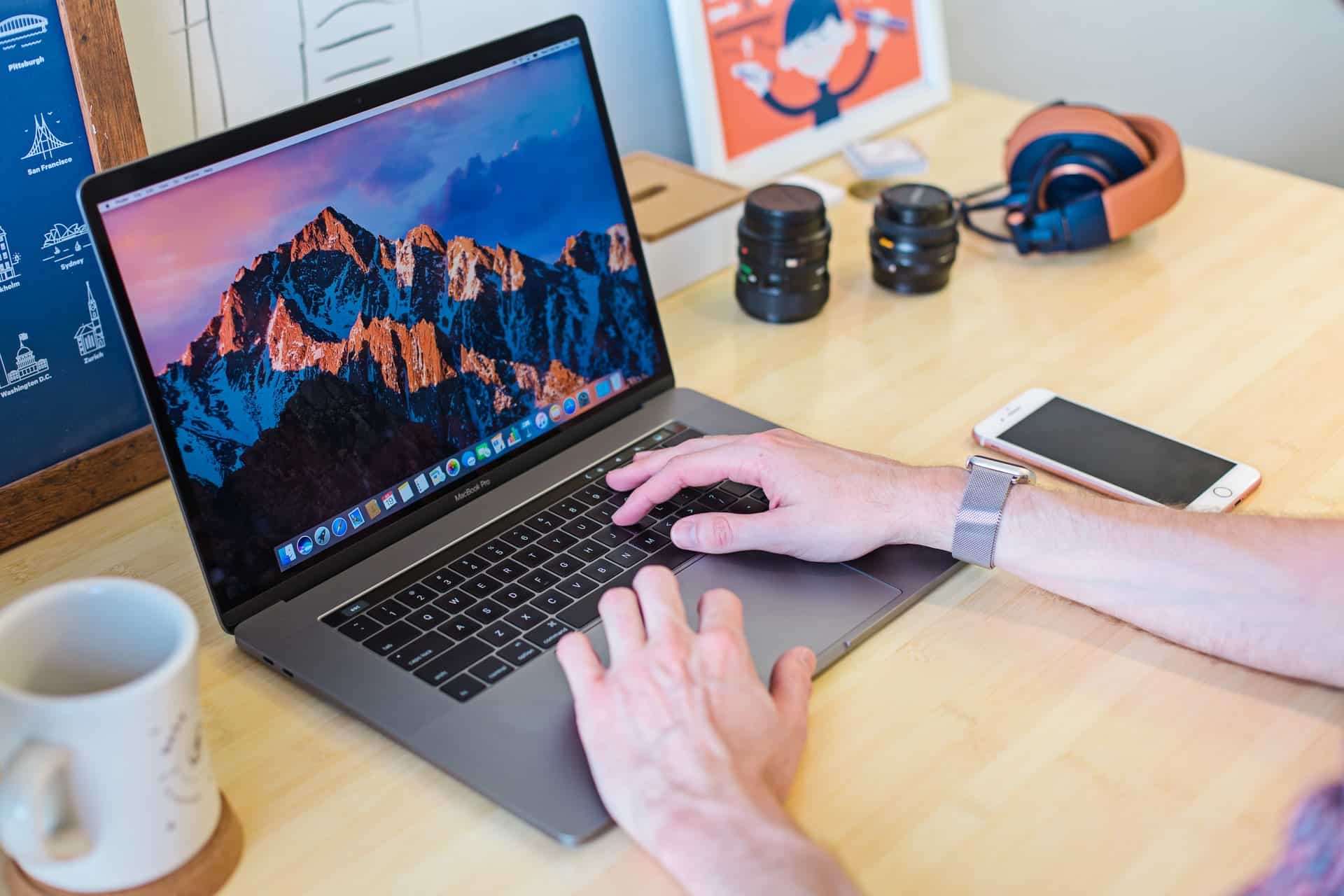 les mains d'une personne sur un clavier d'un macbook