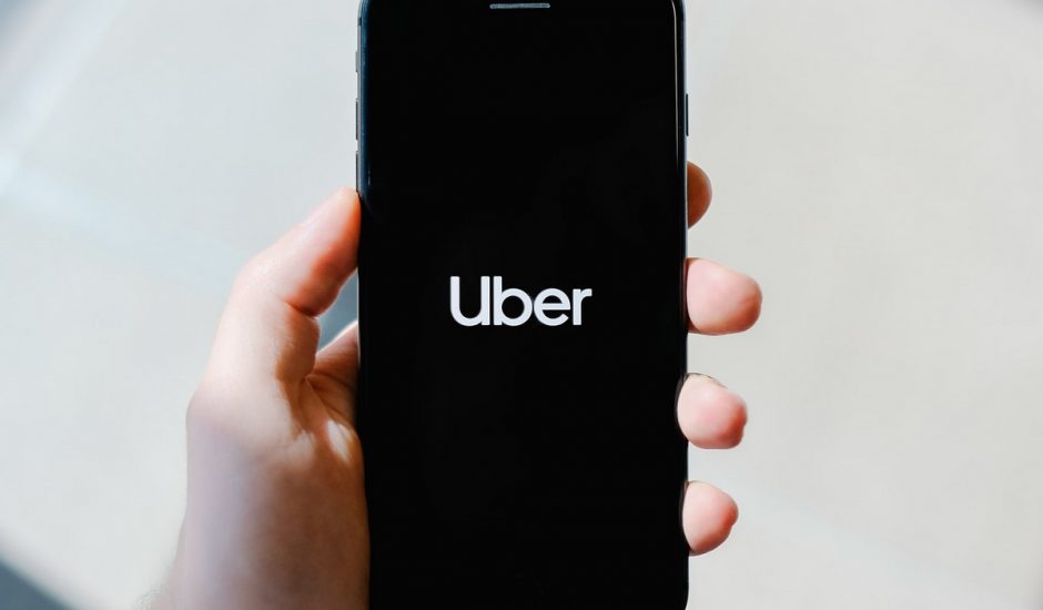 Une personne tenant un smartphone avec l'application Uber ouverte