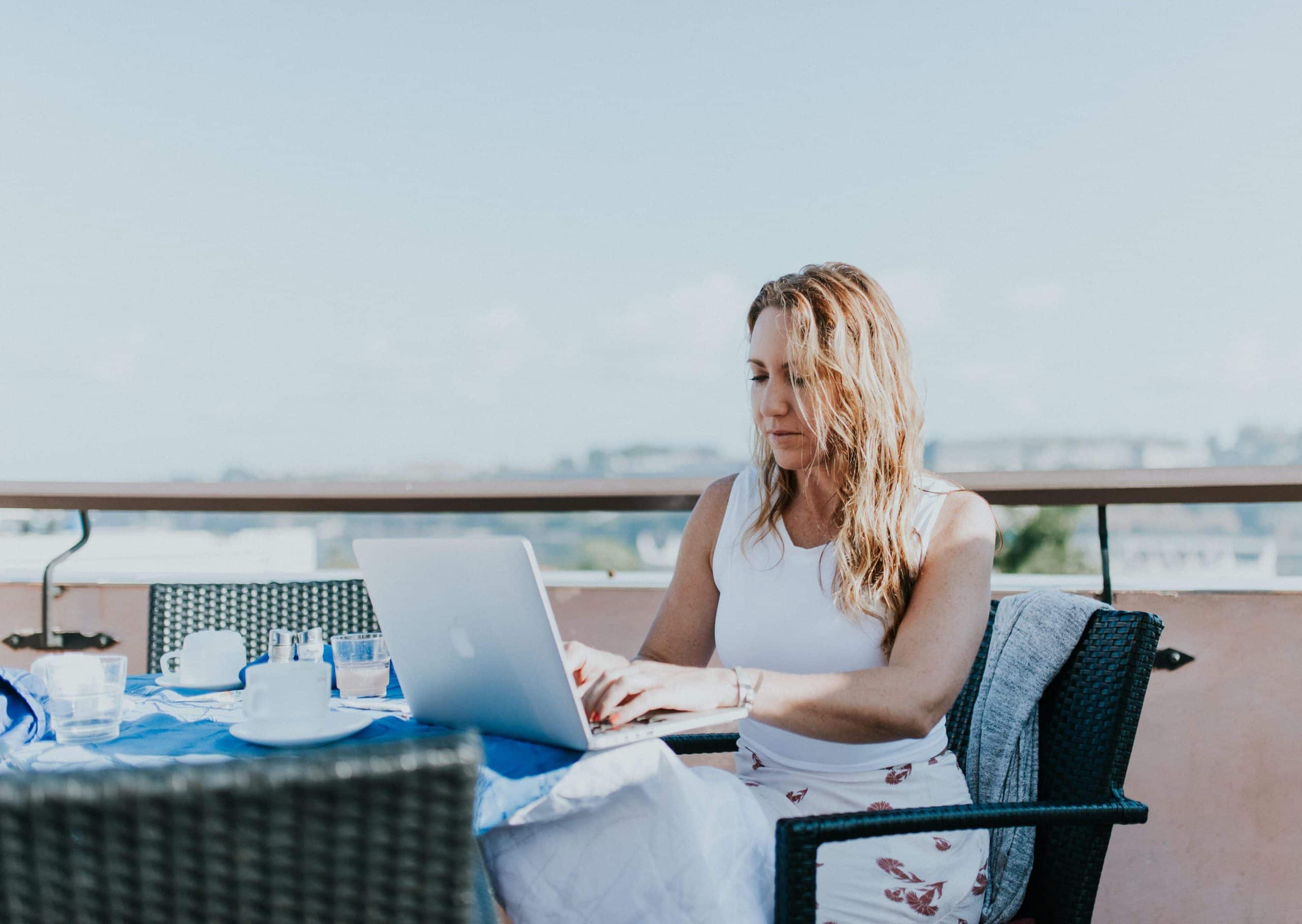une femme sur une terrasse devant un macbook
