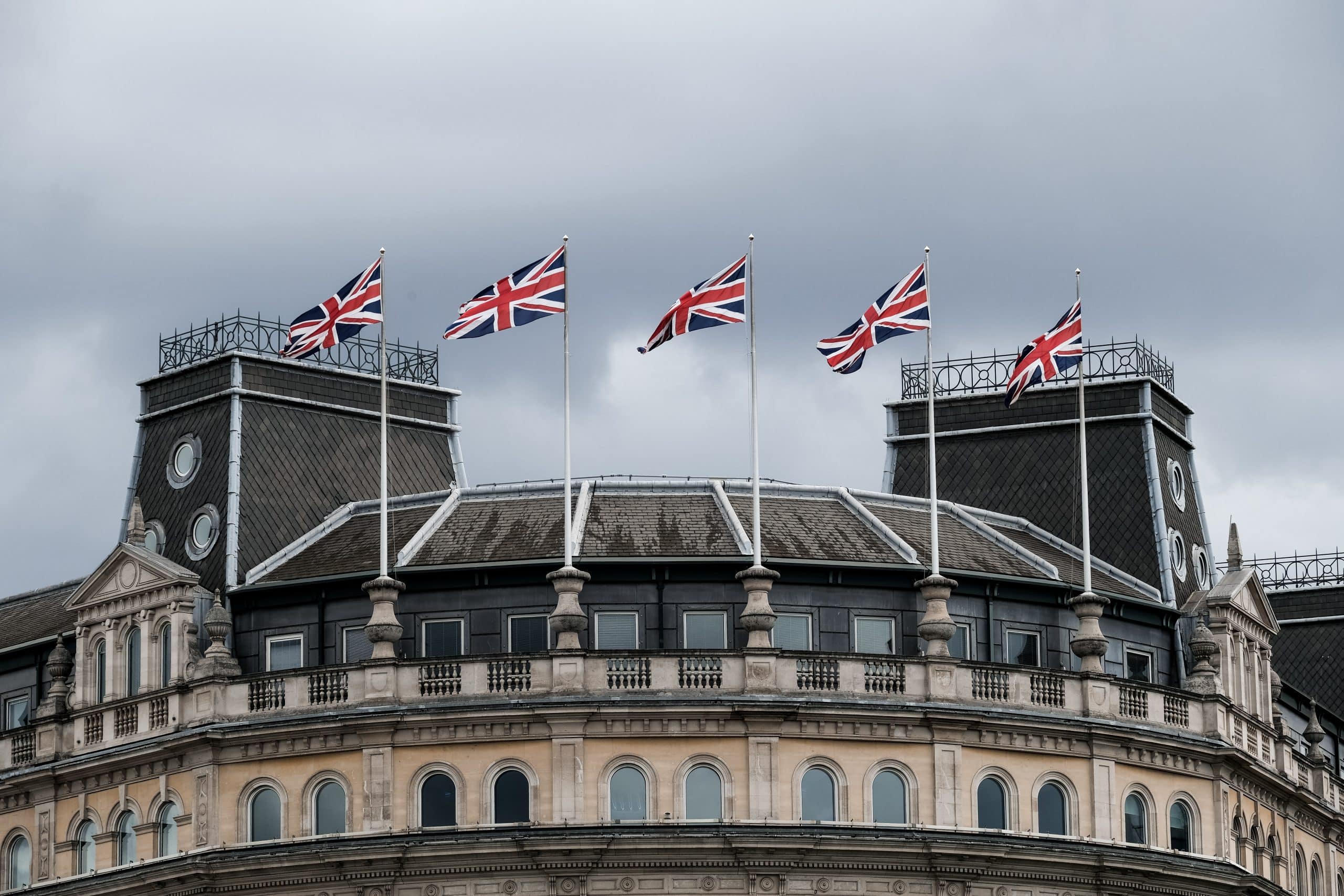 Des drapeaux britanniques flottent devant un monument.
