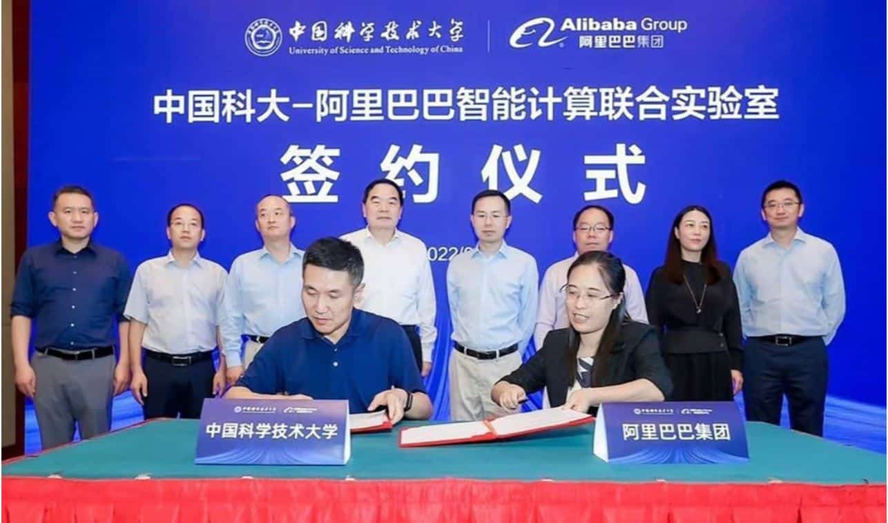 Représentants d'Alibaba et de l'Université de sciences et technologies de Chine signant un document.