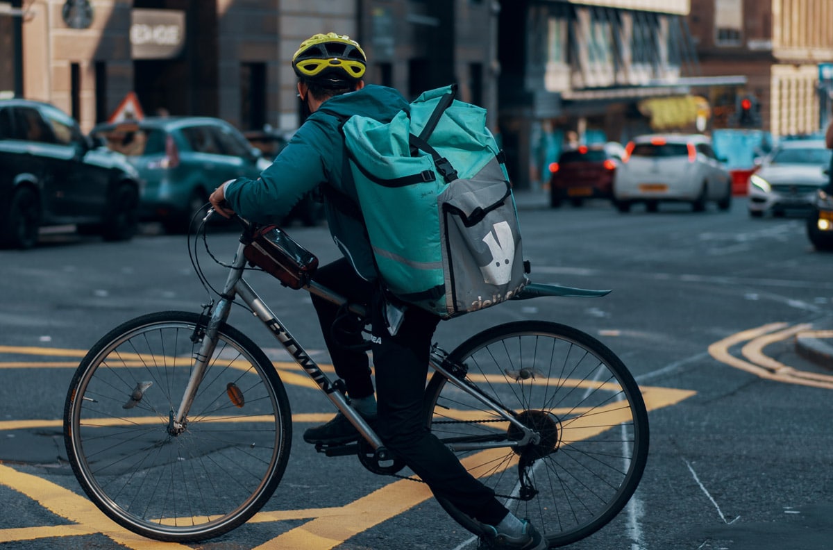 Un livreur Deliveroo sur son vélo dans la rue.