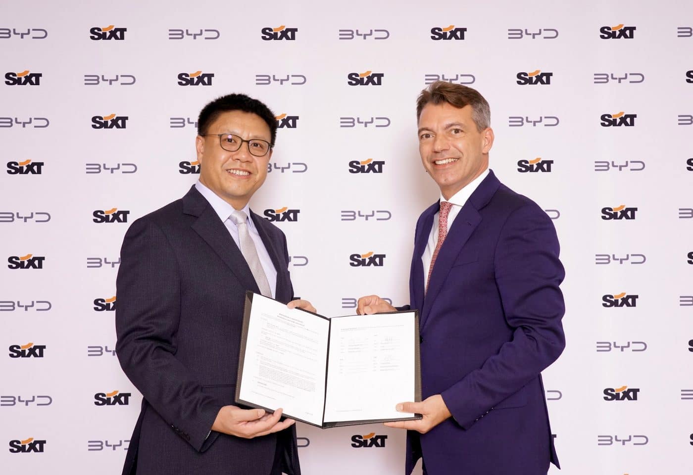 Les PDG de Sixt et BYD montrent la signature d'un accord