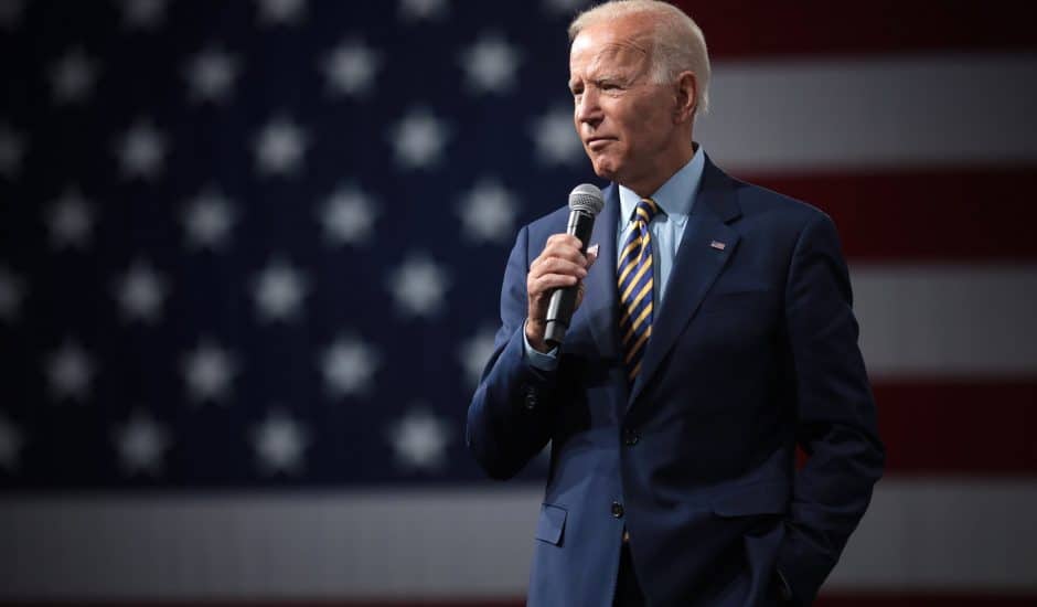 Joe Biden donne un discours avec le drapeau américain en arrière plan.