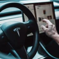 Un homme conduit une Tesla.