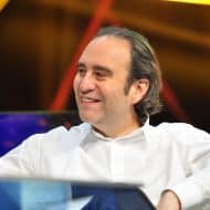Xavier Niel, seated and smiling, wears a white shirt.