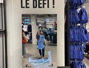 Une femme se prennant en photo devant le miroir connecté d'un magasin