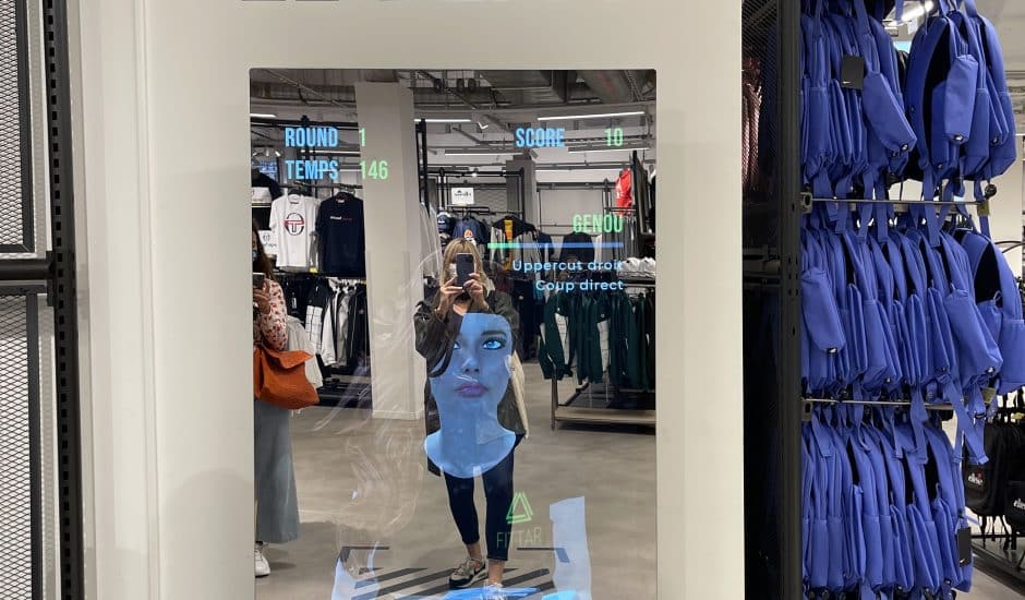 Une femme se prennant en photo devant le miroir connecté d'un magasin