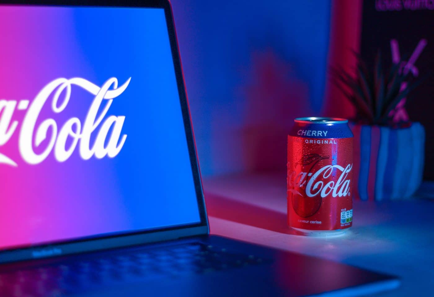 Logo Coca-Cola sur un ordinateur à côté d'une canette de Coca-Cola