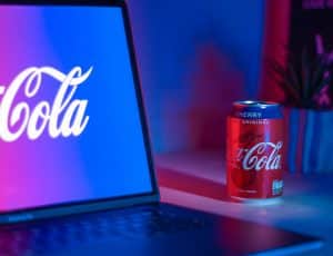 Logo Coca-Cola sur un ordinateur à côté d'une canette de Coca-Cola