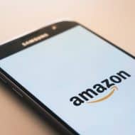 Photograph of a phone screen with the Amazon logo.