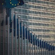 Une lignée de drapeaux européens devant la Commission Européenne.