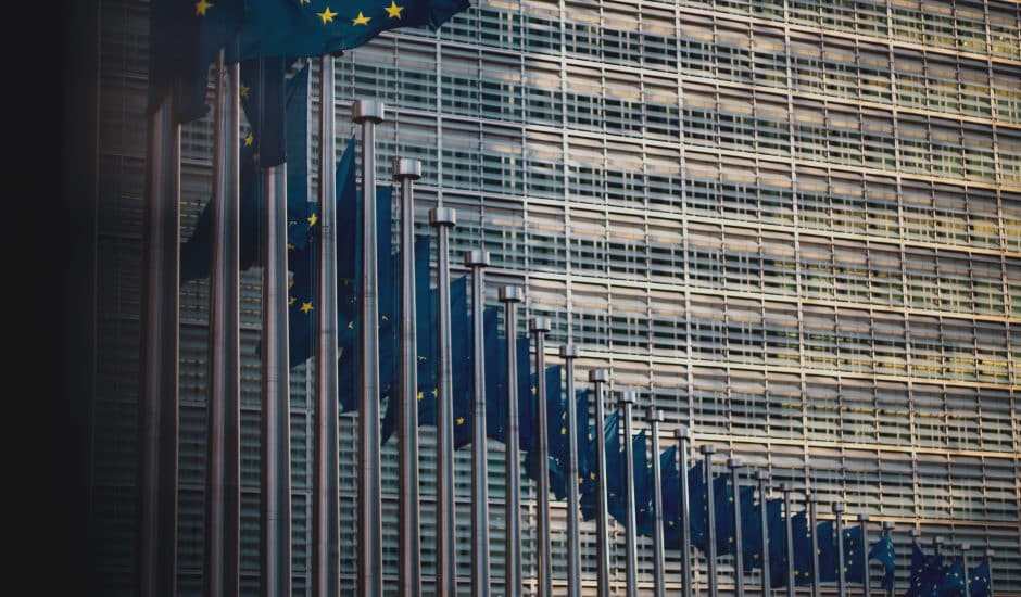 Une lignée de drapeaux européens devant la Commission Européenne.