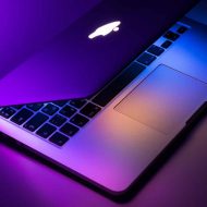 Un Macbook d'Apple photographié avec des couleurs sombres style néon
