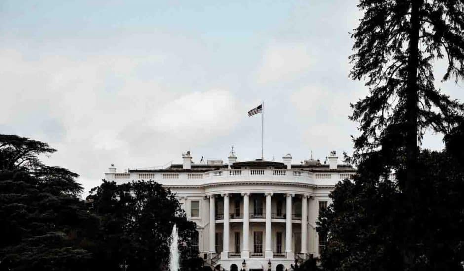 La Maison-Blanche photographiée de loin, un drapeau américain flottan au dessus