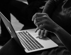 Une photo en noir et blanc d'une personne travaillant sur un macbook.