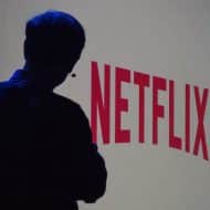 L'ombre de Reed Hastings devant le logo de Netflix.