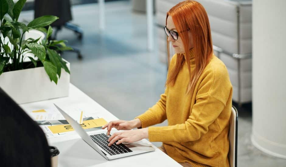 une femme habillée en jaune sur un ordinateur portable