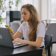 une femme sur son téléphone devant son ordinateur