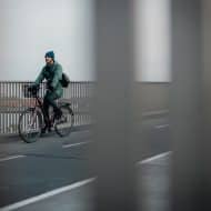 un homme sur un vélo, photo prise entre des barreaux