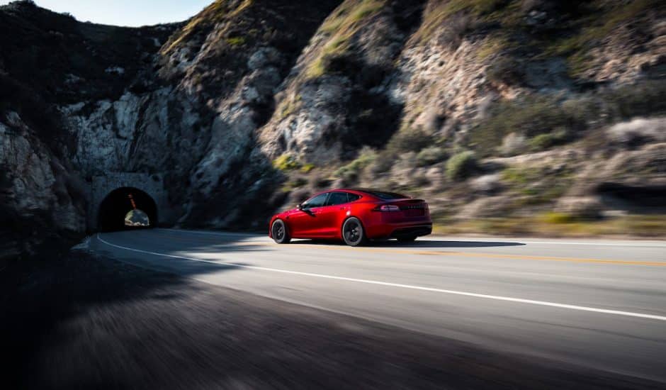 Voiture modèle S rouge Tesla qui roule sur une route montagneuse