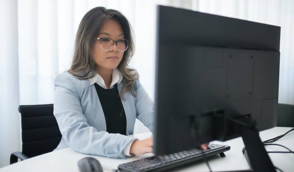 une femme en train de travailler devant un ordinateur à son bureau