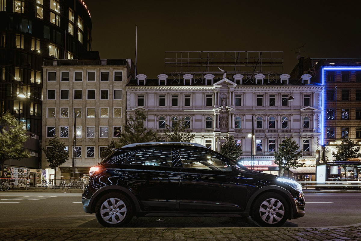 une voiture noire roulant la nuit en ville