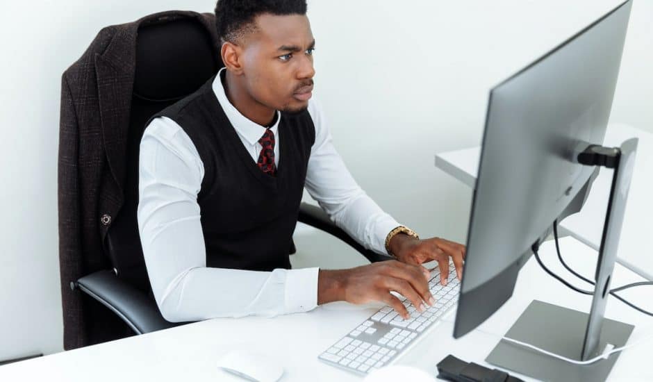 un homme concentré devant son ordinateur de bureau