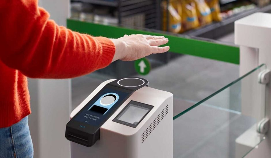 Une personne présente sa main au-dessus d'un scanner pour effectuer un paiement.