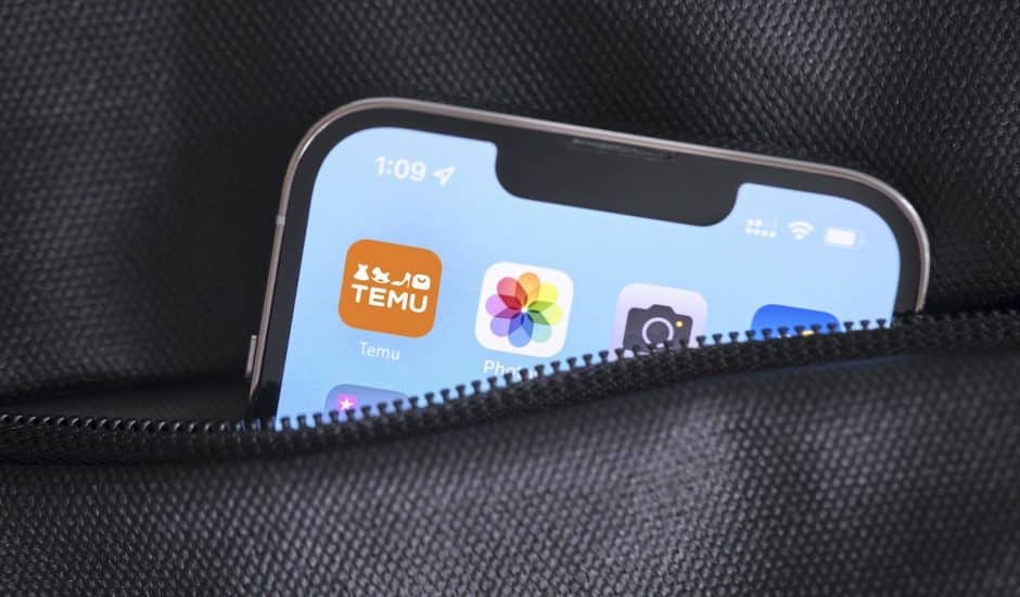 un iphone dans une poche avec l'icône de Temu en avant