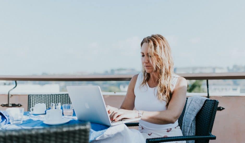 une femme sur un ordinateur à une terrasse
