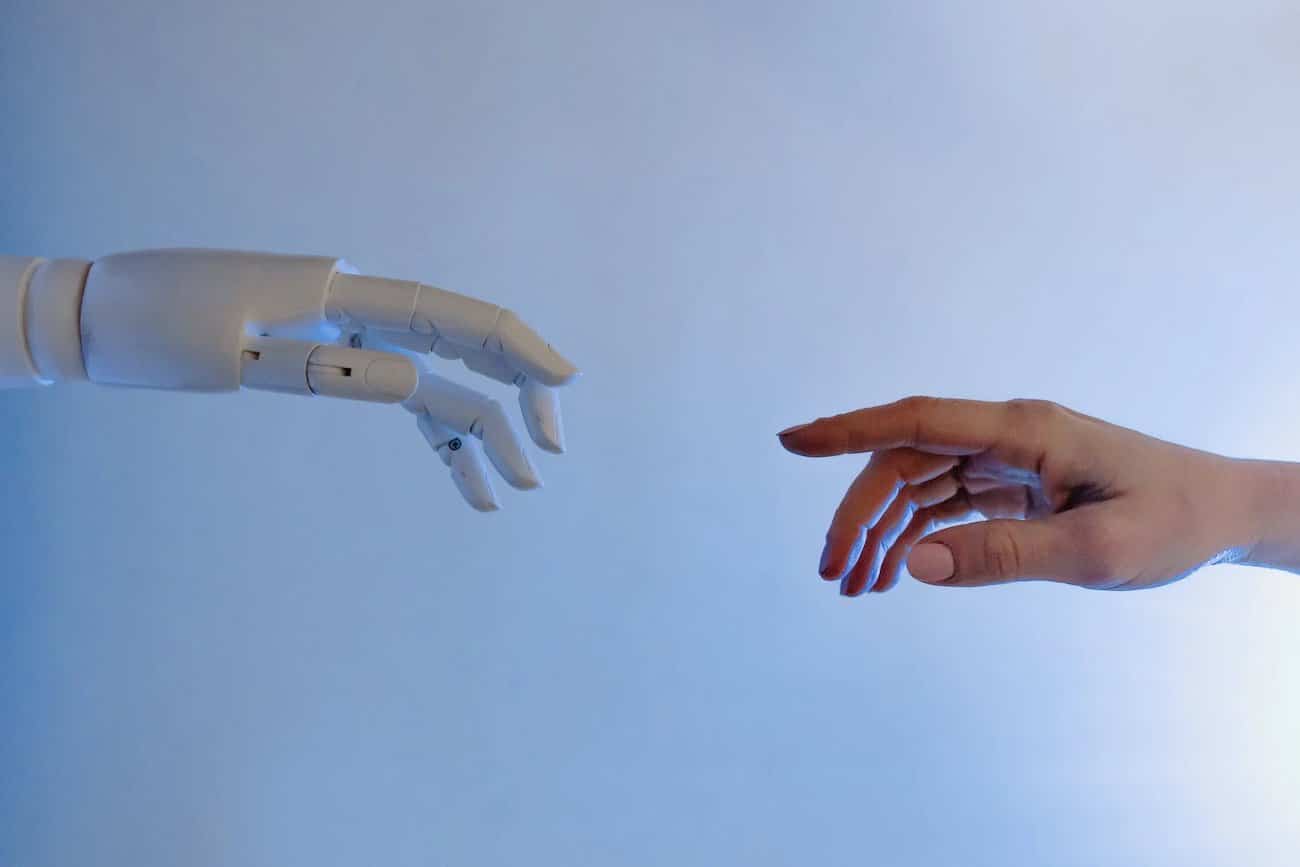 Une main robotisée et une main humaine symbolisant le lien entre l'Homme et la machine.