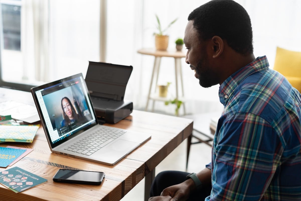 un homme devant son écran en vidéoconférence avec une femme sur Zoom
