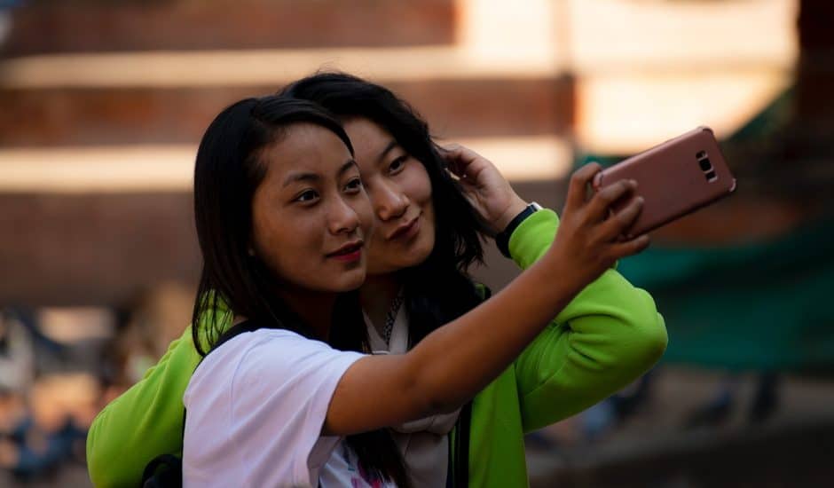 Deux filles népalaises prenant un selfie dans la rue