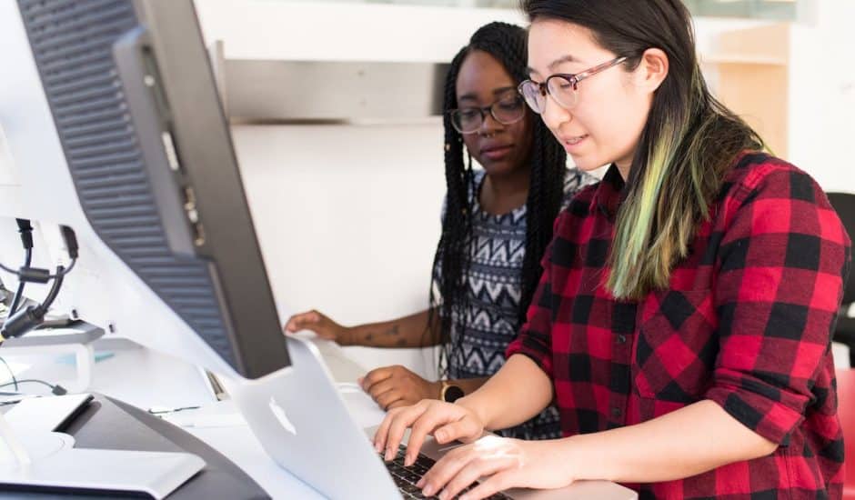 deux femmes devant un ordinateur en train de travailler