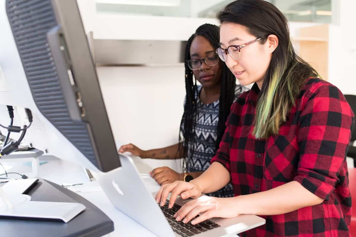 deux femmes devant un ordinateur en train de travailler